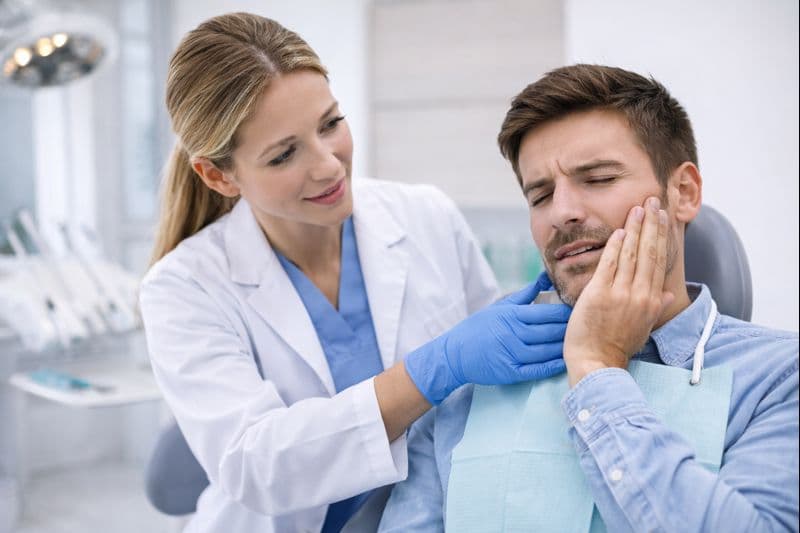 Akut tandvärk behandling i Borås – kvinnlig tandläkare hjälper patient med tandsmärta